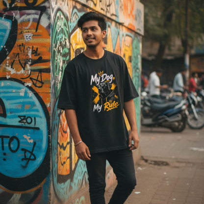 Man wearing a black t-shirt with graphic design and text, standing in front of a colorful graffiti wall.