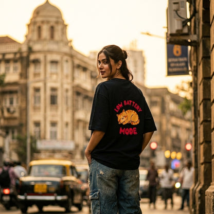 Person wearing a black t-shirt with 'Low Battery Mode' graphic in an urban setting