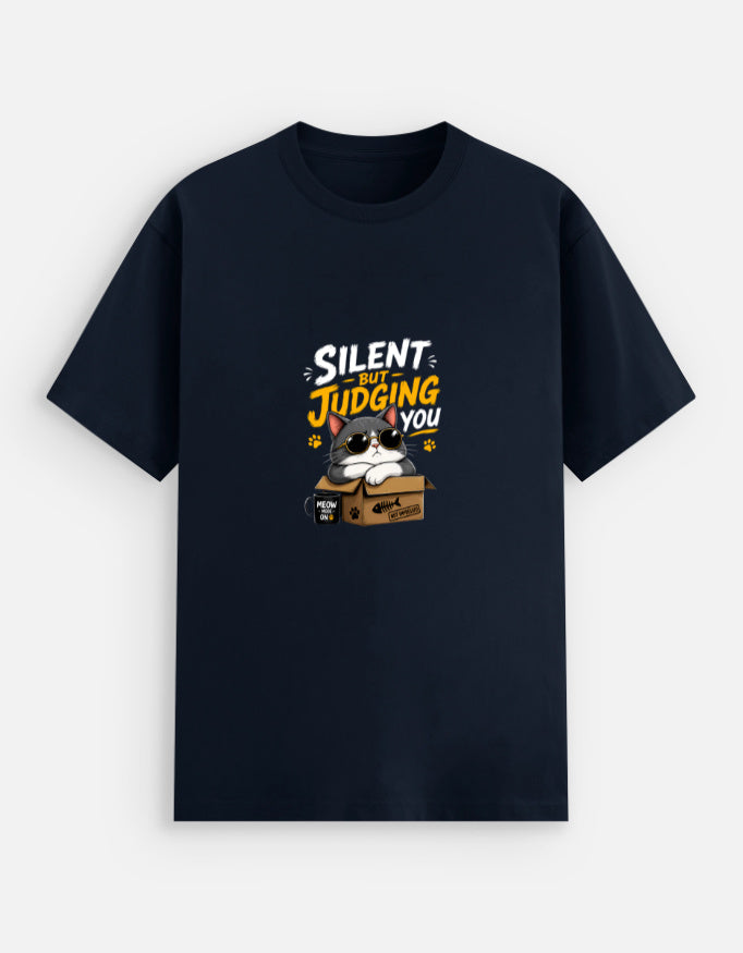 Navy Blue unisex stretch t-shirt featuring a cute sunglasses-wearing cat sitting on a box with the text “Silent But Judging You” in bold yellow and white typography, humorous meme-style graphic design on chest.